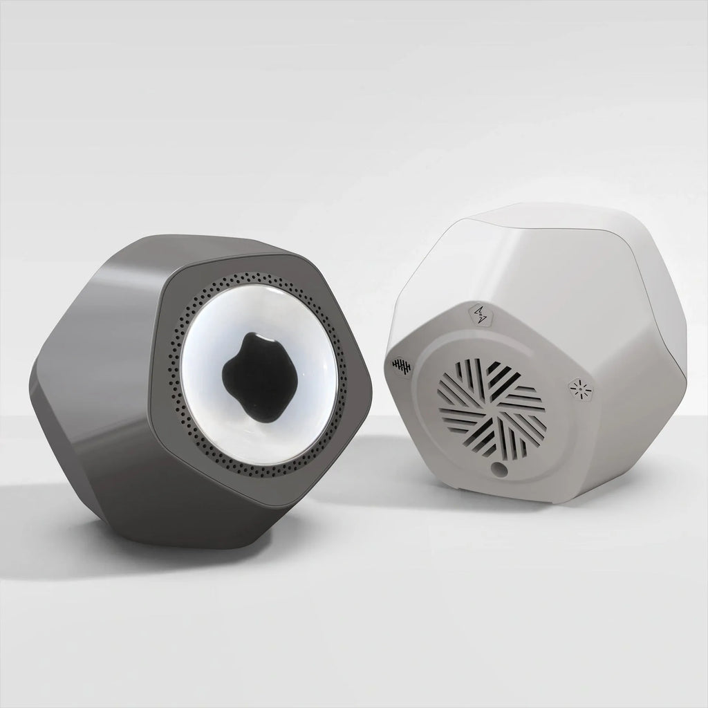 Floating magnetic fluid Bluetooth speaker in silver gray on a desktop, with magnetic fluid swirling inside the chamber