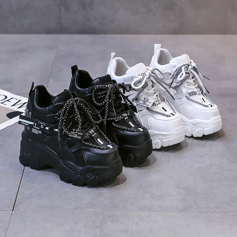 White women's low-top platform sports shoes with cross-strap and round toe on a rubber sole.
