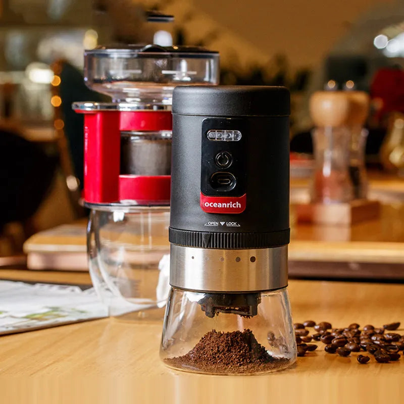Black portable hand crank coffee grinder with manual grinding mechanism on counter