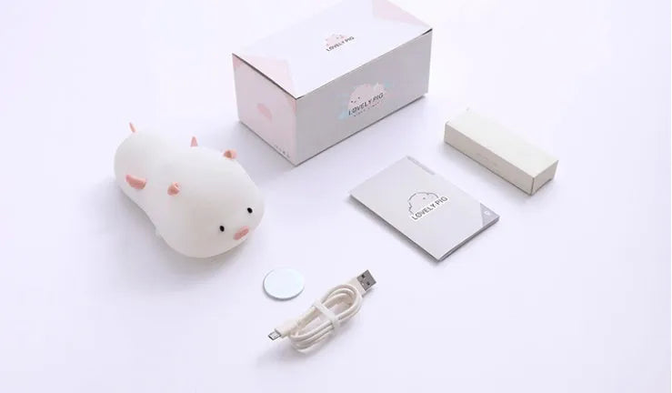 Blue silicone pig-shaped night light with USB charging port