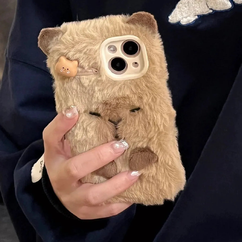 Brown furry plush capabala phone case for iPhone showing cartoon face and flannel texture