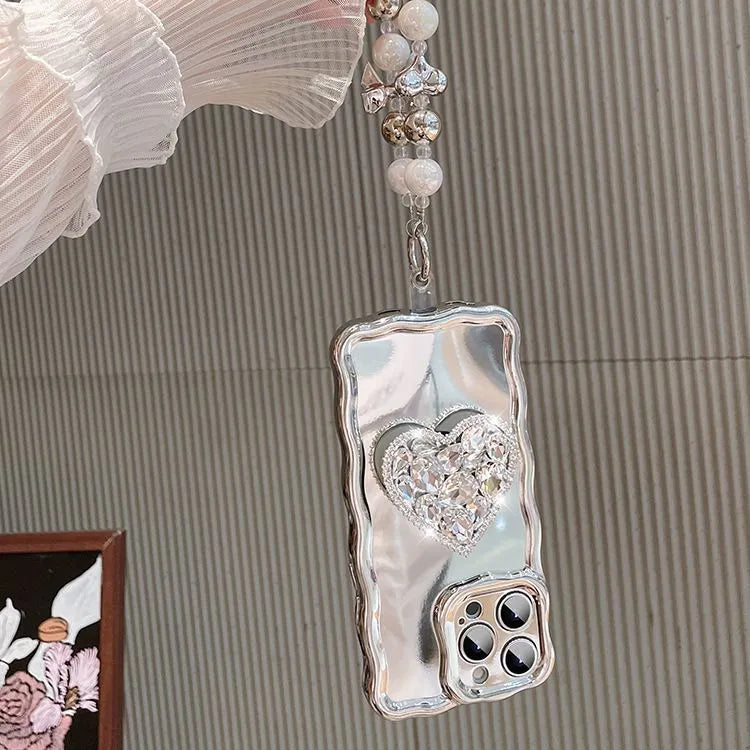 Silver grey silicone iPhone case with mirror finish, rhinestone bracket, and wrist strap lanyard.