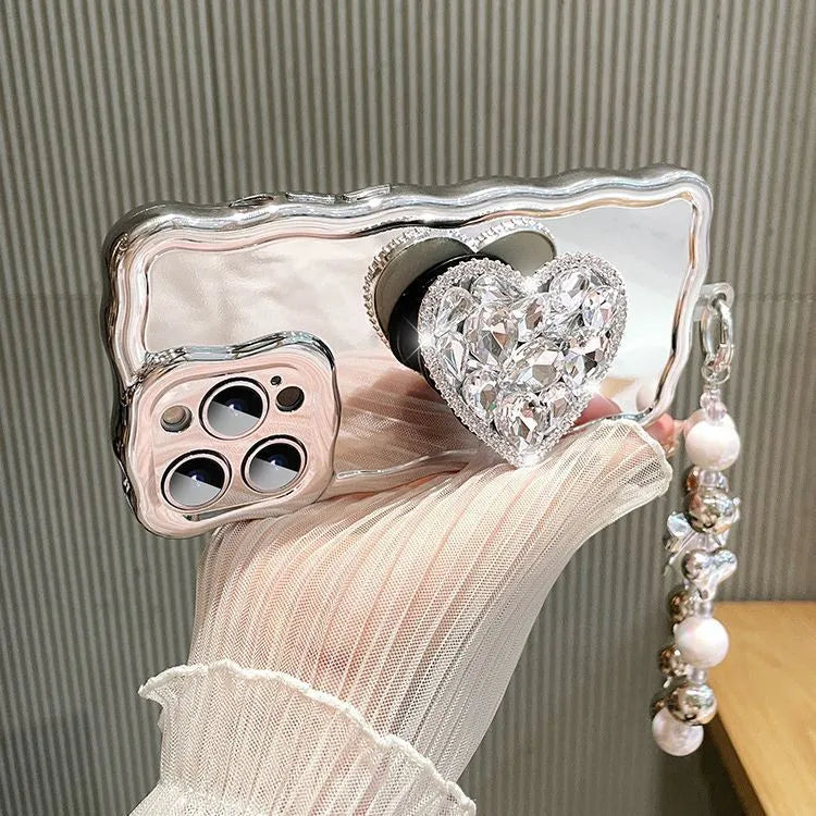 Silver grey silicone iPhone case with mirror finish, rhinestone bracket, and wrist strap lanyard.