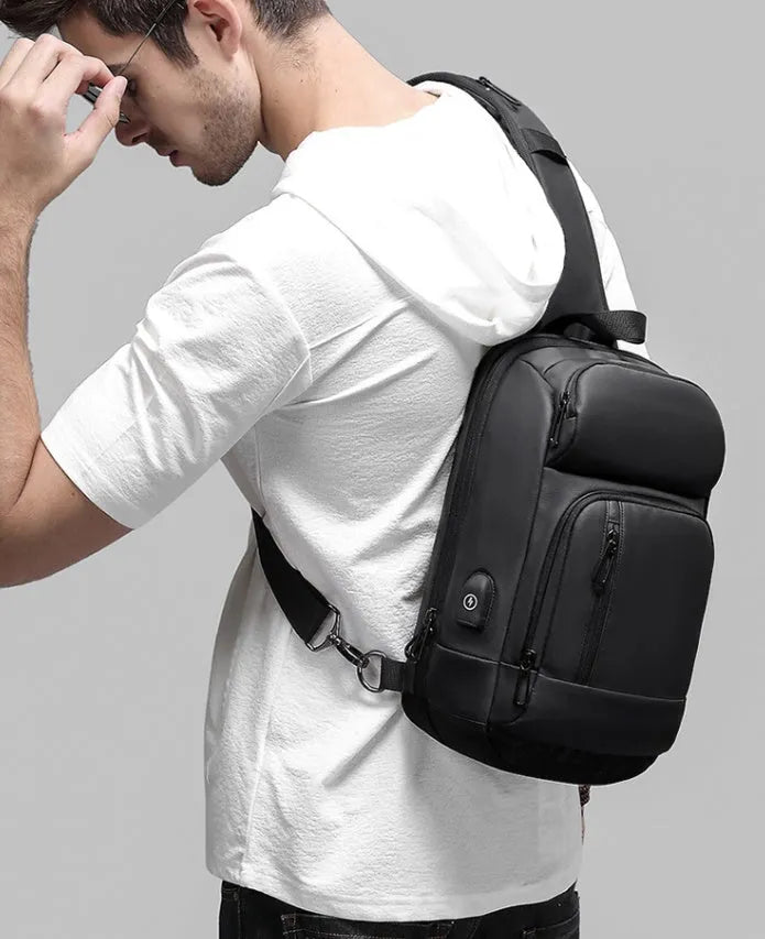 Black PVC outdoor shoulder bag with adjustable strap and internal laptop compartment