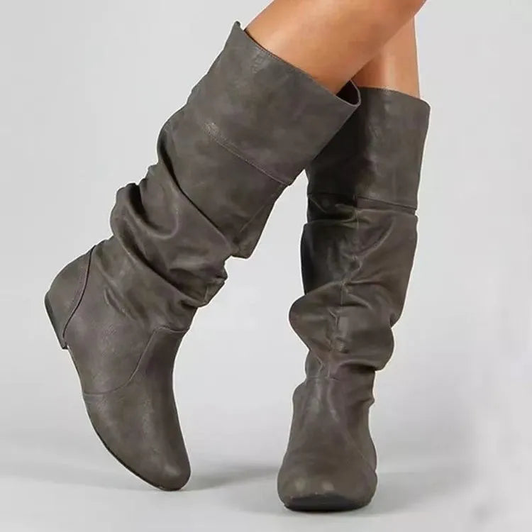 Women's black slip-on flat ankle boots with a round toe and high cylinder shaft.