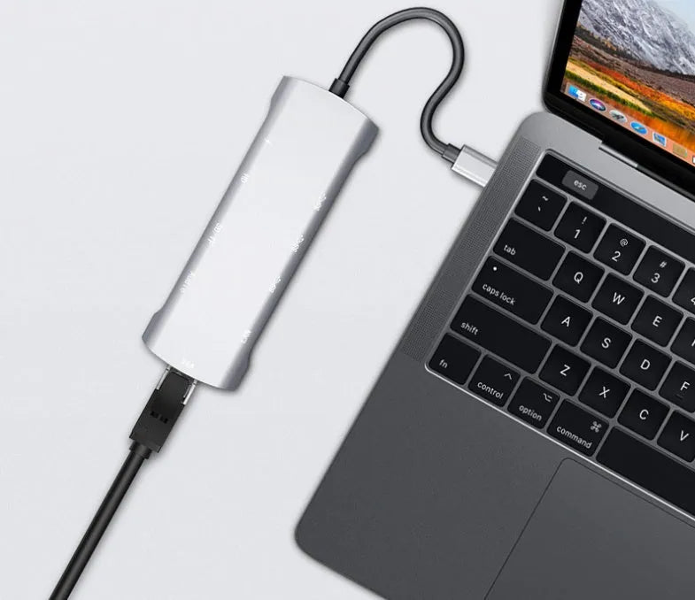 Grey aluminium alloy USB-C docking station with HDMI, VGA, USB ports, and a card reader.