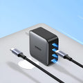 Compact white 100W Gallium Nitride fast charger plug with multiple USB-C ports on a desk.