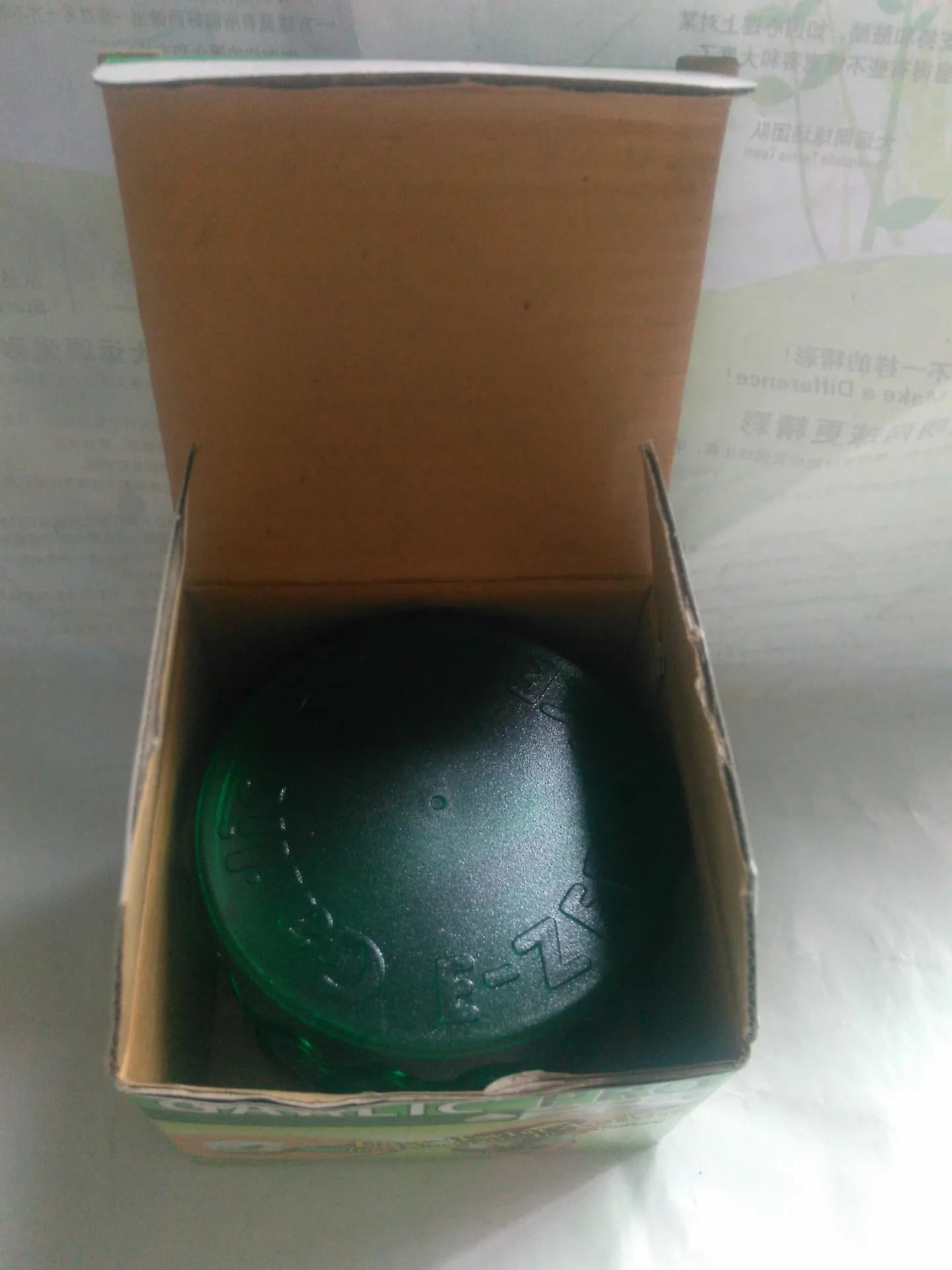 Green transparent silicone garlic peeler tube on a kitchen counter