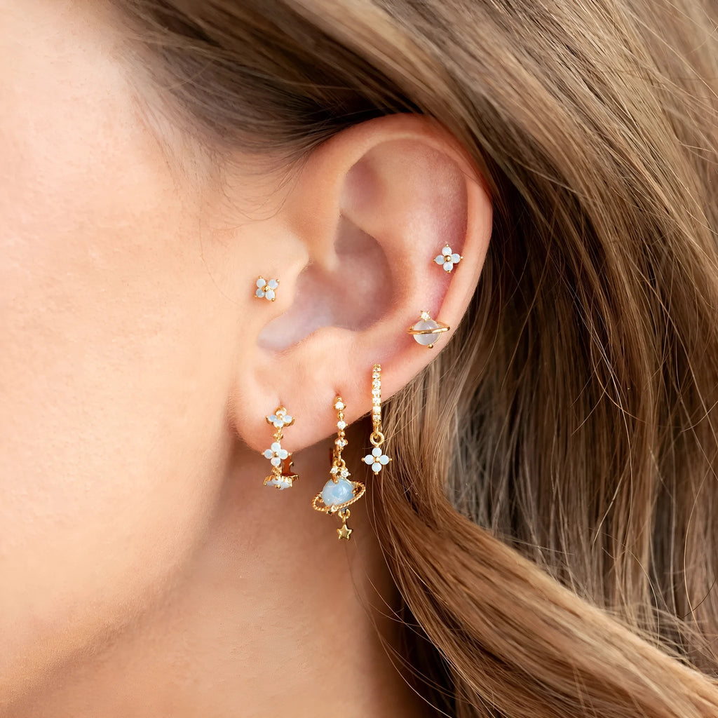 Gold and silver flower-shaped ear studs with blue zircon mosaic decoration.
