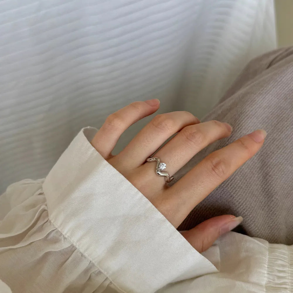 Women's silver electroplated open ring with single diamond and smooth wave line design, white gold tone
