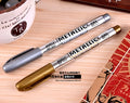 Gold and silver metallic marker pens on a white background