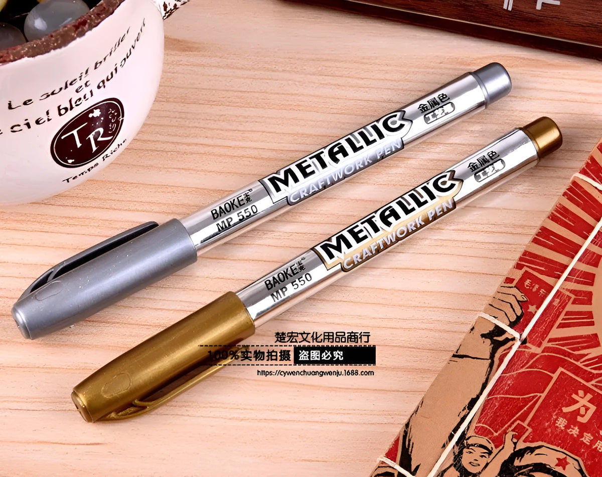 Gold and silver metallic marker pens on a white background