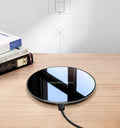 Black QI wireless charging pad with a smooth plastic surface and silicone non-slip base.