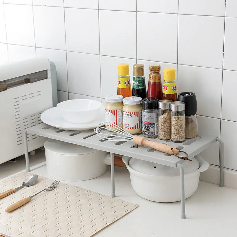 White telescopic plastic kitchen storage rack at adjustable height