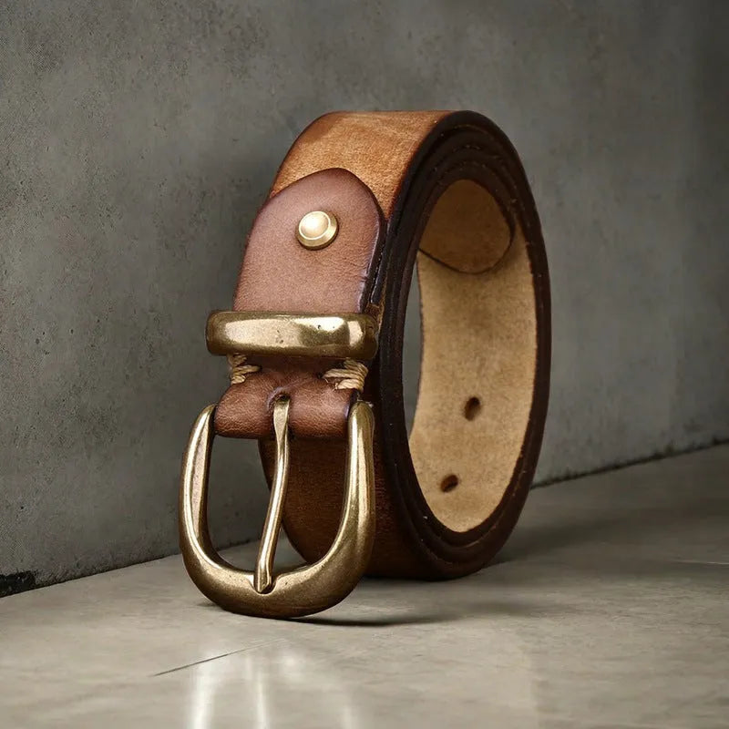Men's casual leather belt in black with a copper pin buckle on a jeans background