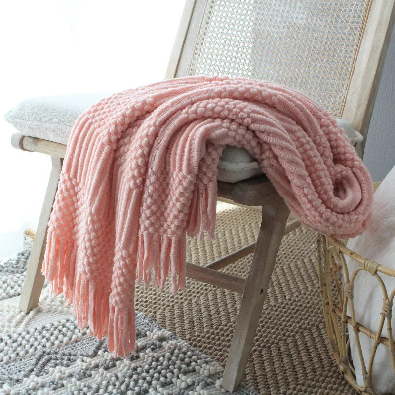 Nordic knitted bubble blanket in acrylic and polyester fibre, 127x170cm, shown as a plain sofa throw in light grey, light khaki, or pink.