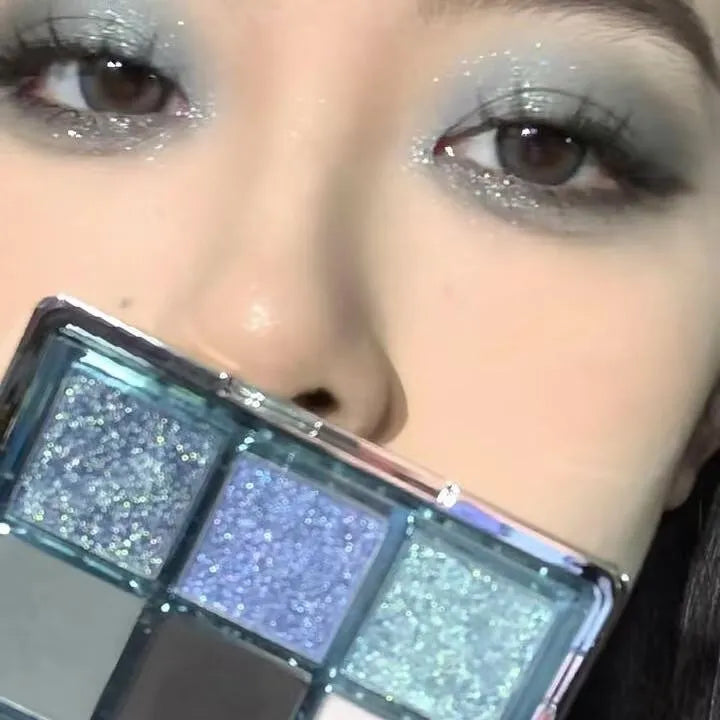 MUGELEEN nine-colour eye shadow palette open showing blue smoked and earth tone shades with matte and shimmer finishes.