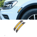 Set of four fluorescent reflective car wheel brow adhesive strips in blue, red, white, and yellow on a black car wheel arch