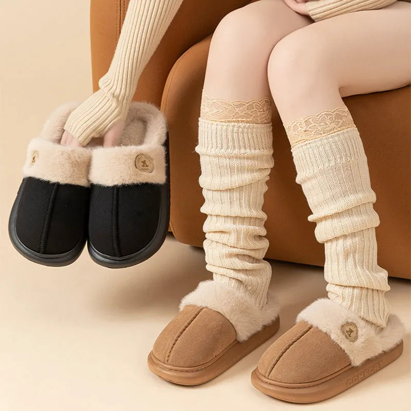Pair of thick-soled fleece indoor slippers in a chosen colour, showing car stitching detail on the upper.