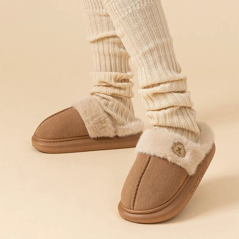 Pair of thick-soled fleece indoor slippers in a chosen colour, showing car stitching detail on the upper.