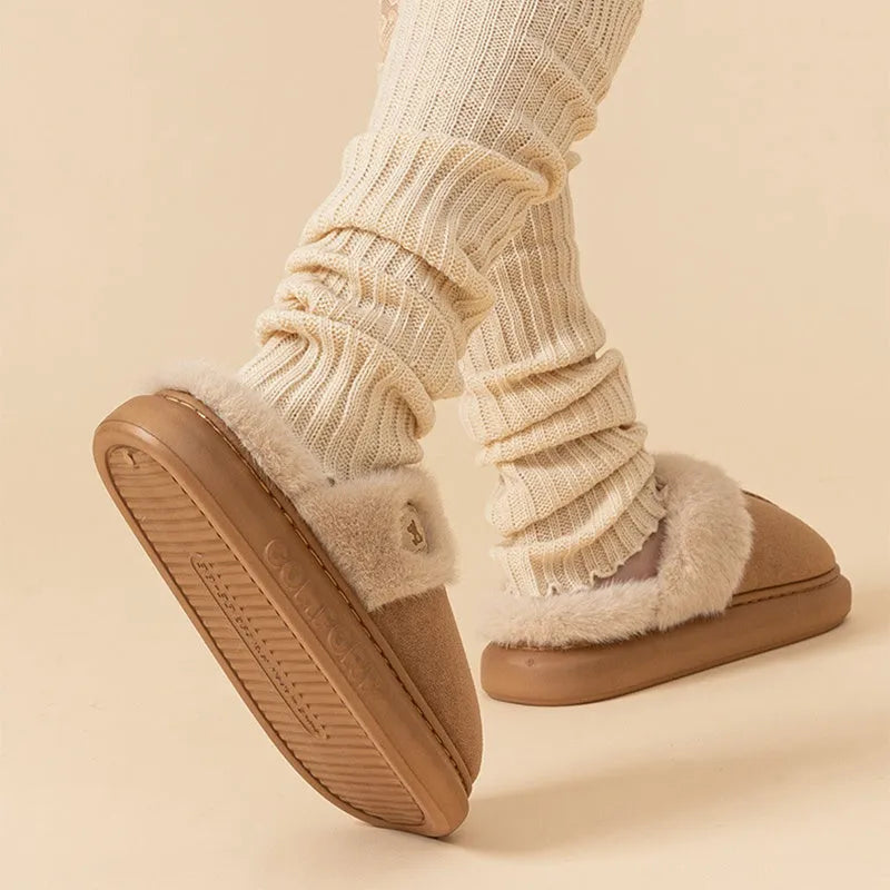 Pair of thick-soled fleece indoor slippers in a chosen colour, showing car stitching detail on the upper.