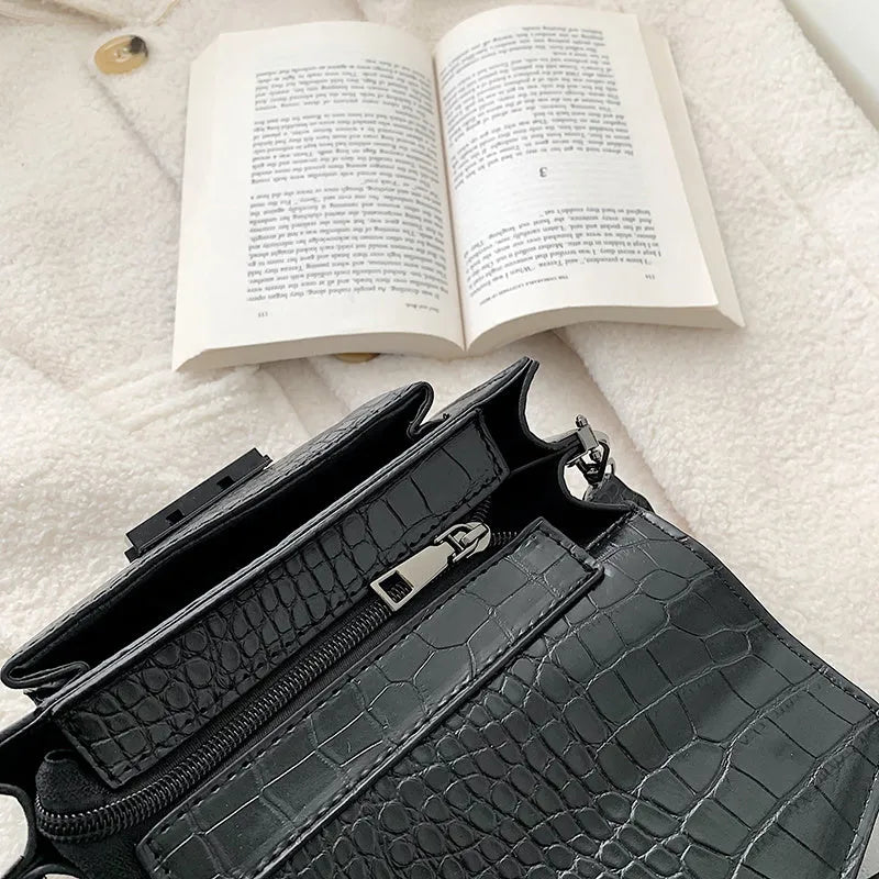 Vintage PU leather crossbody bag in black showing interior organisation for phones and wallets