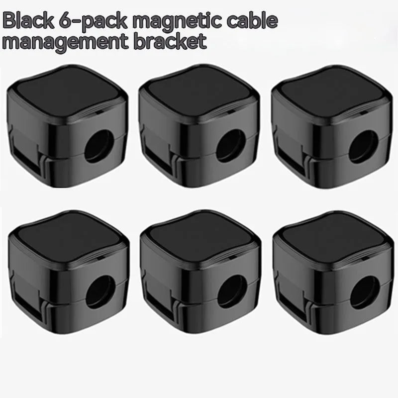 White and black magnetic cable clips holding a USB cable against a wooden desk edge.