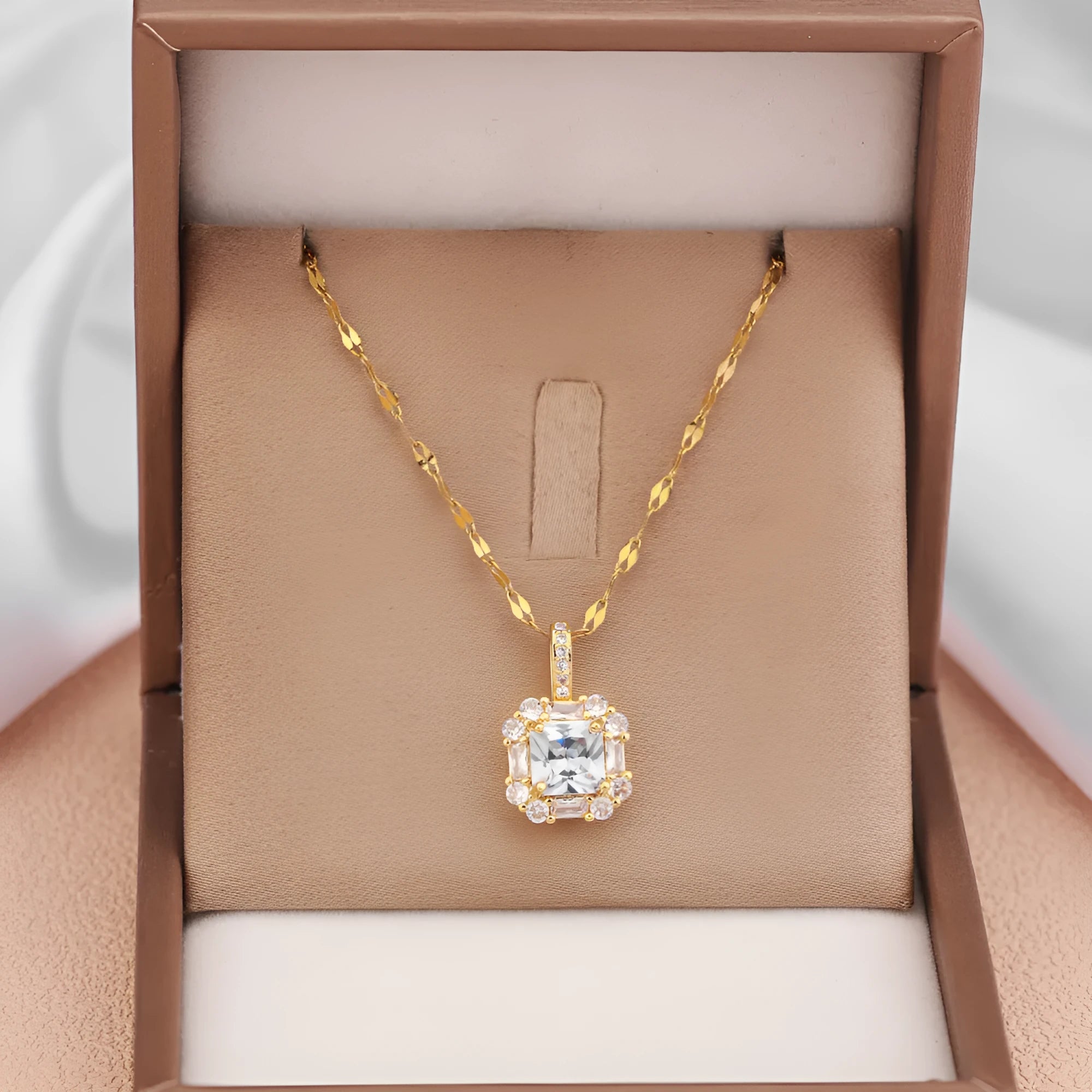 Gold-toned titanium steel necklace with geometric quadrilateral zircon pendant on a water wave chain.