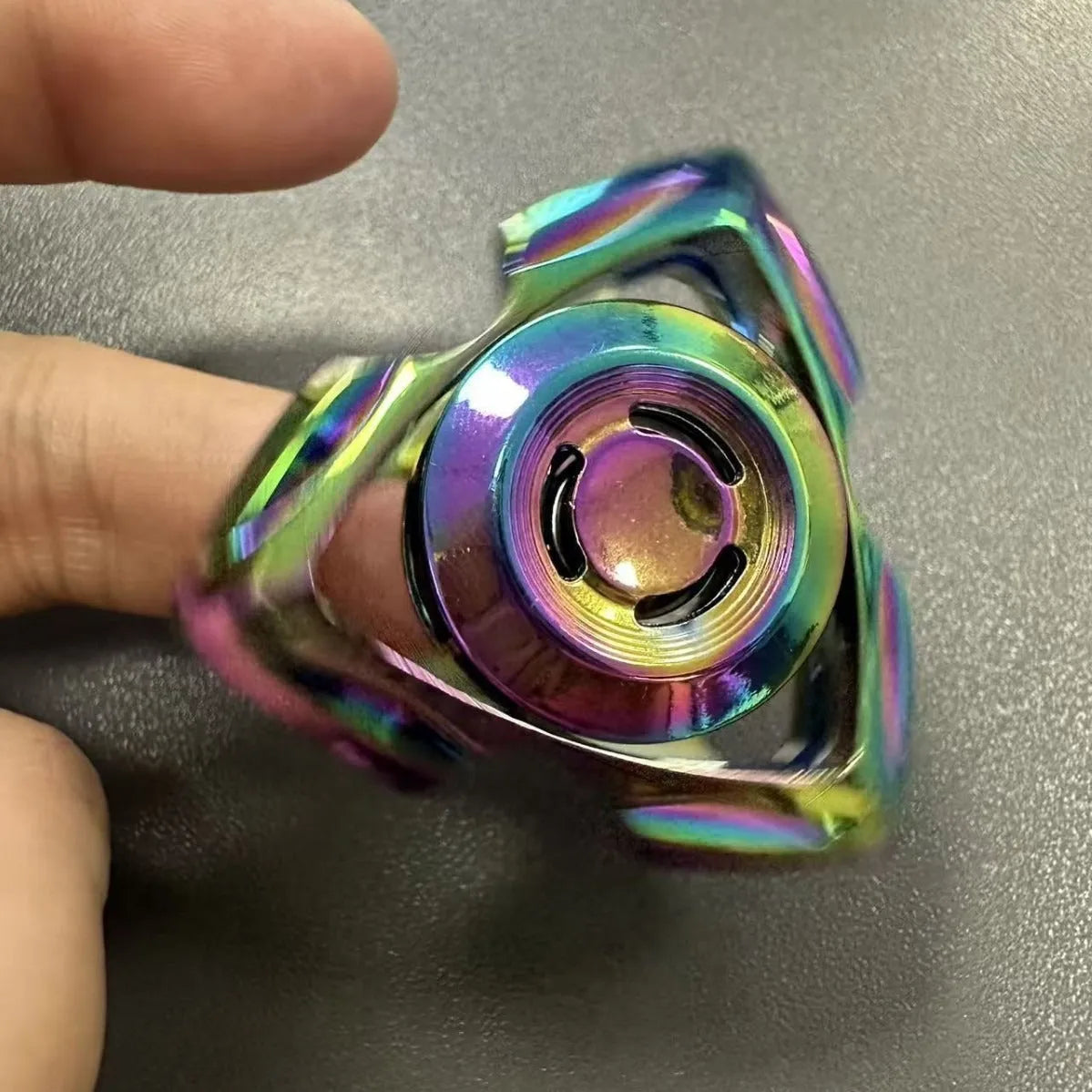 A silver and colourful alloy metal fingertip gyro decompression spinner toy.