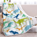 Dinosaur themed white sherpa fleece lamb wool blanket folded on a sofa