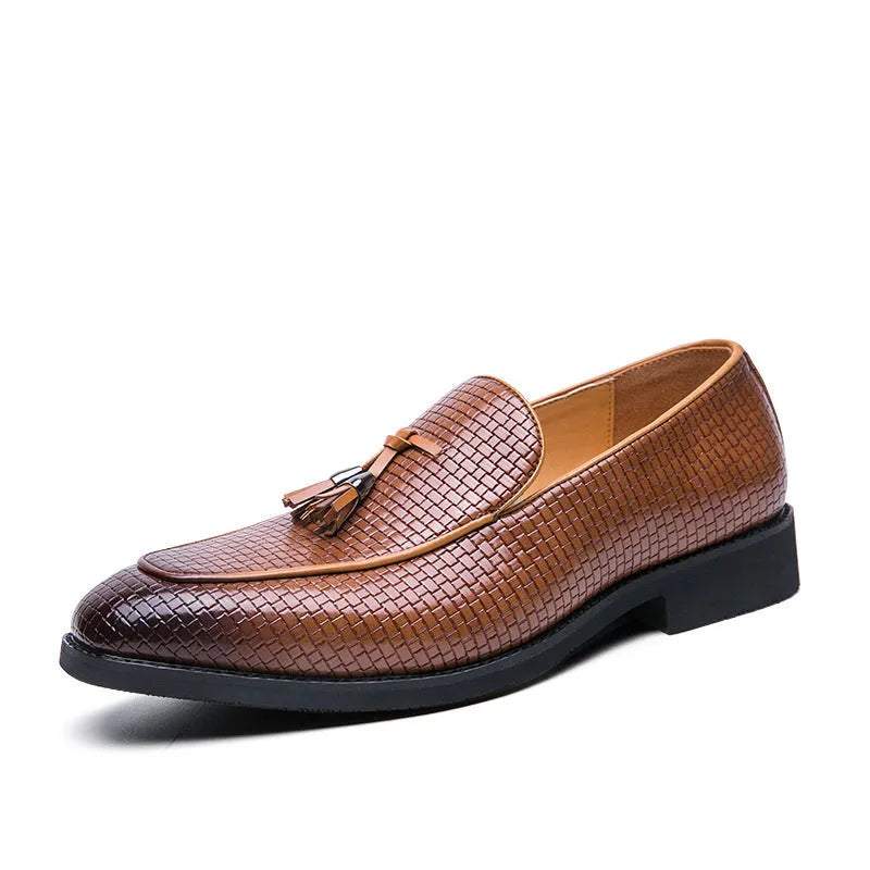 Men's black slip-on leather loafers with a pointed toe and tassel detail on a white background.