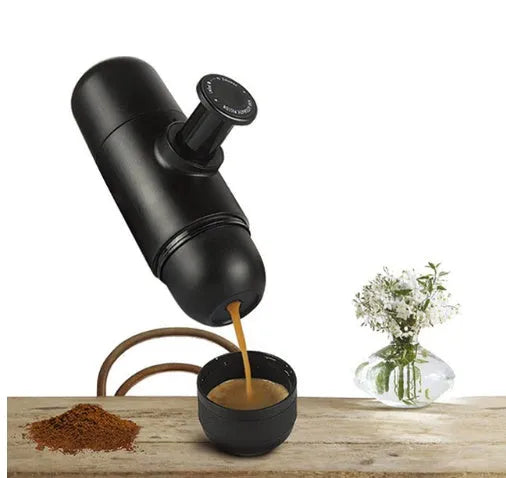 Black portable manual coffee machine showing compact size and manual operation components.