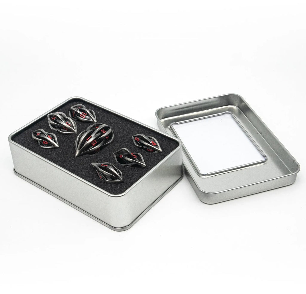 Seven metal melon seed shape dice in antique silver with coloured characters on a surface