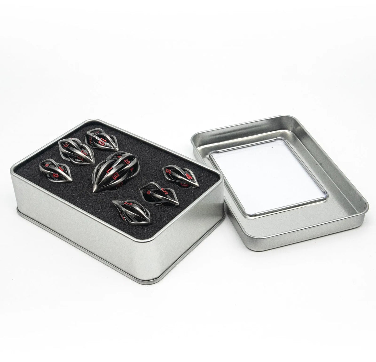 Seven metal melon seed shape dice in antique silver with coloured characters on a surface