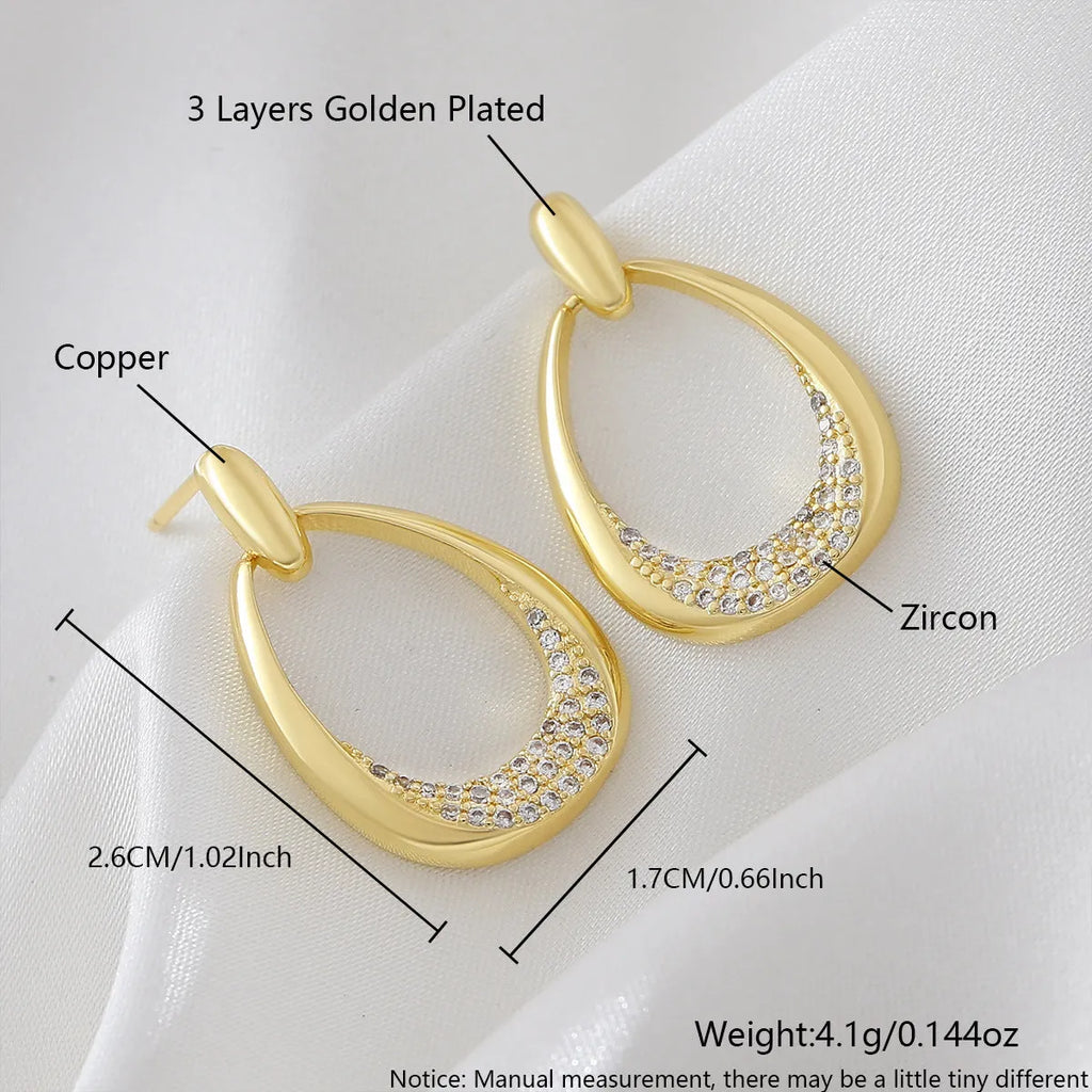 Yellow gold geometric drop earrings for women with simple zircon details on a copper base.