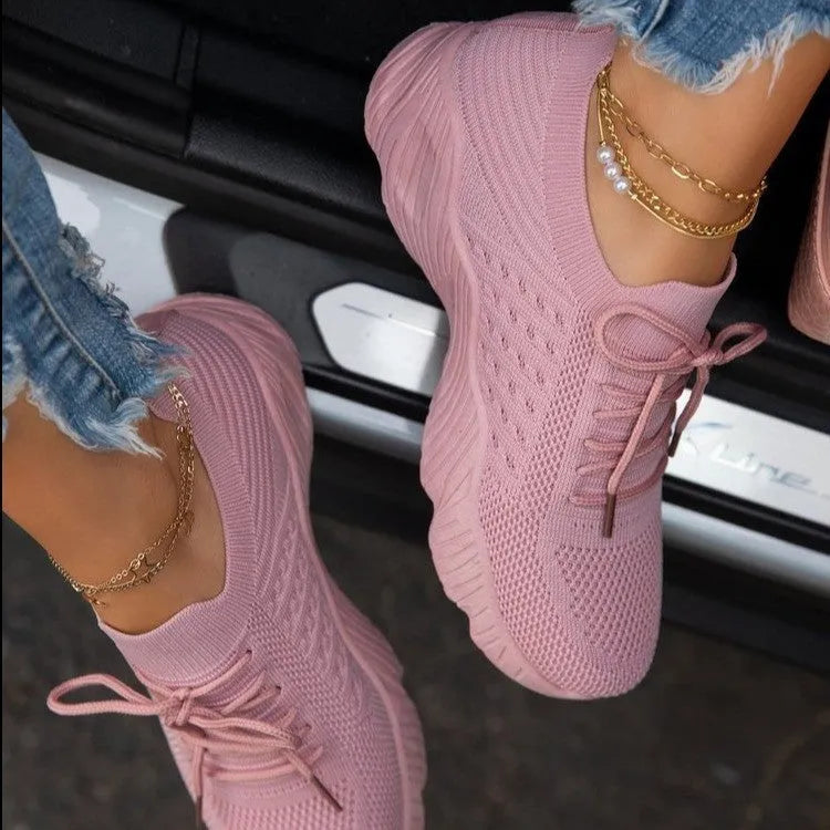 Women's white thick-sole dad-style sports sneakers on a neutral background.