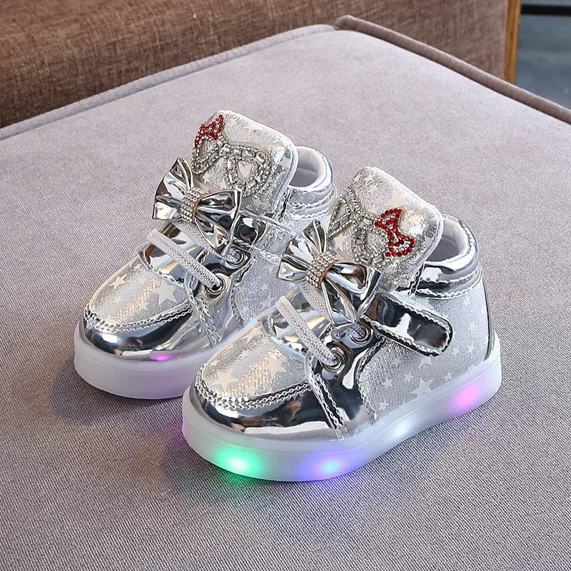 Children's LED light-up trainers with glowing rainbow soles in golden, pink and silvery colours