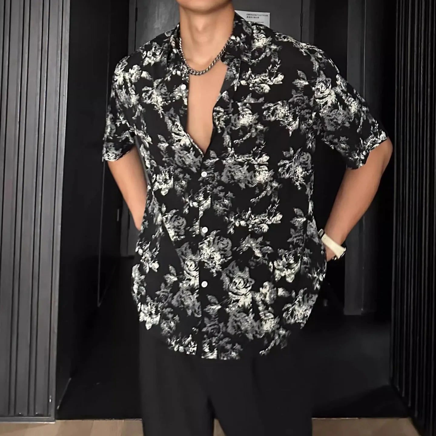 Loose-fitting floral print short sleeve shirt cardigan in black, laid flat.