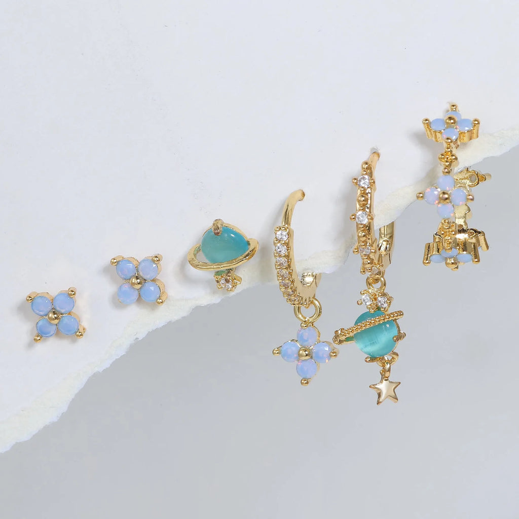 Gold and silver flower-shaped ear studs with blue zircon mosaic decoration.