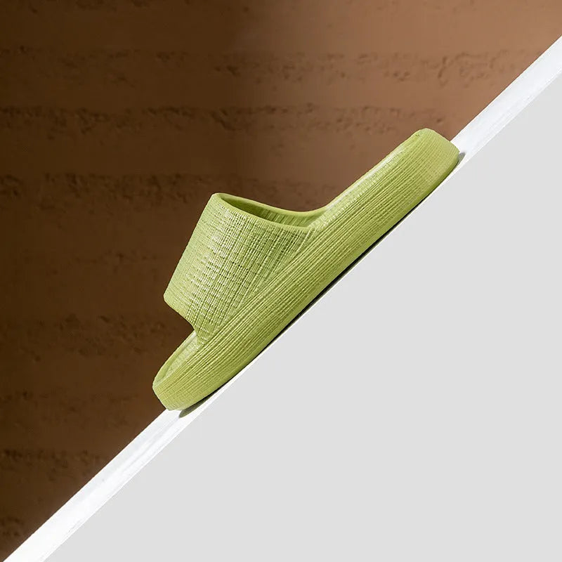 Women's soft EVA non-slip bath slipper in black, showing toe ring flip-flop design and textured sole.