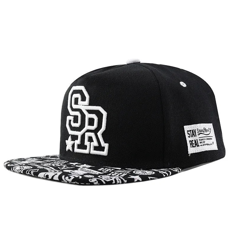 A black cotton baseball cap with embroidered lettering on the front, showing the adjustable strap at the back.
