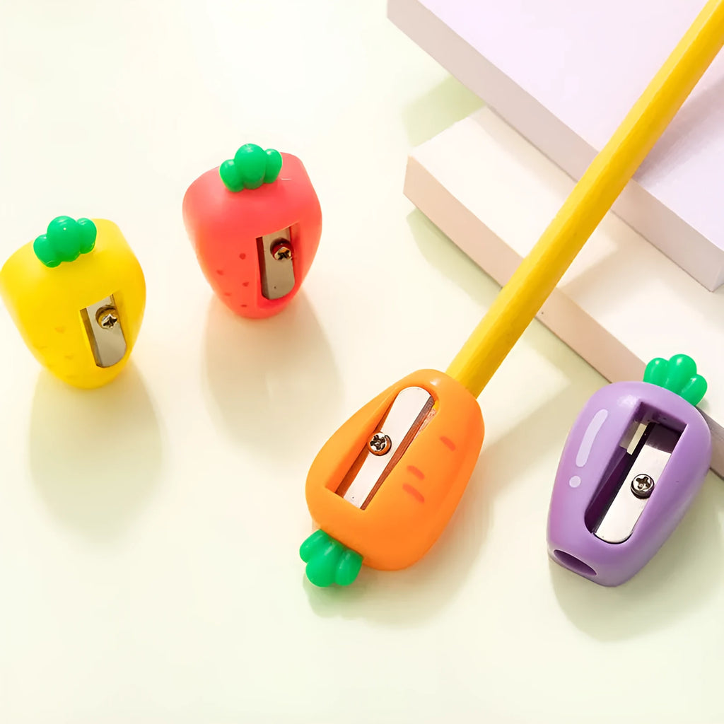Four fruit and vegetable shaped mini pencil sharpeners in random colours on a light surface