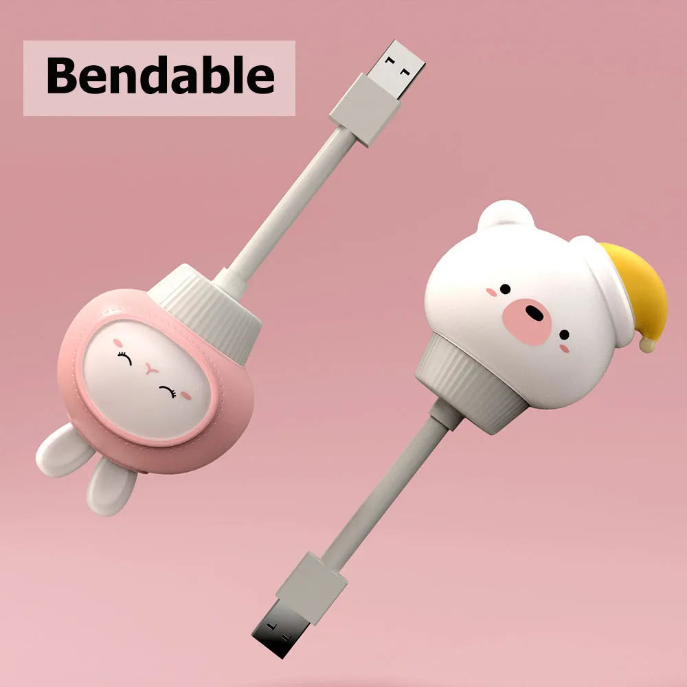 USB portable cartoon animal LED night light with remote control on a bedside table.