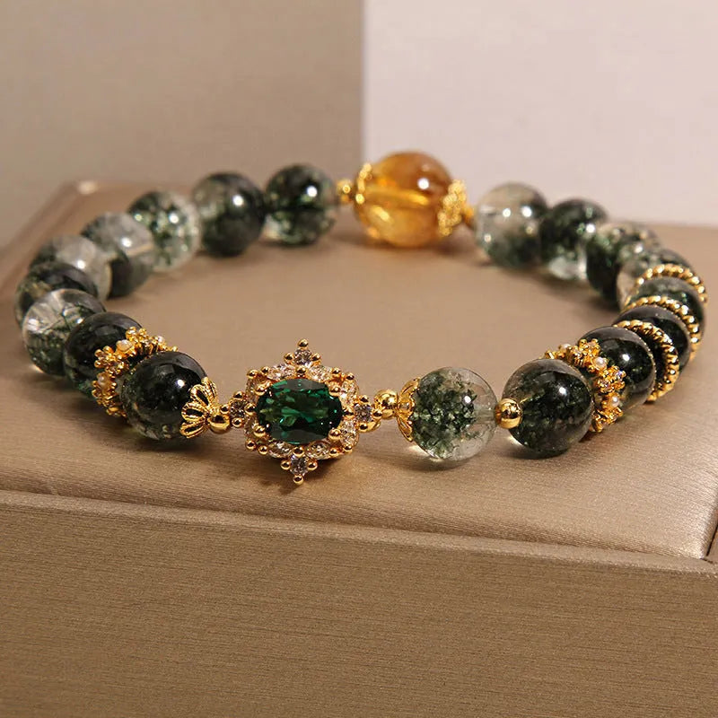 Women's gold rutilated quartz crystal bracelet with green phantom quartz accents, pearls, and rhinestones.