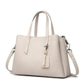 Women's cowhide leather shoulder handbag in horizontal square shape with tassel details and organised interior compartments