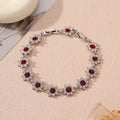 Women's floral charm bracelet in gold or silver electroplate with coloured gemstone effects.