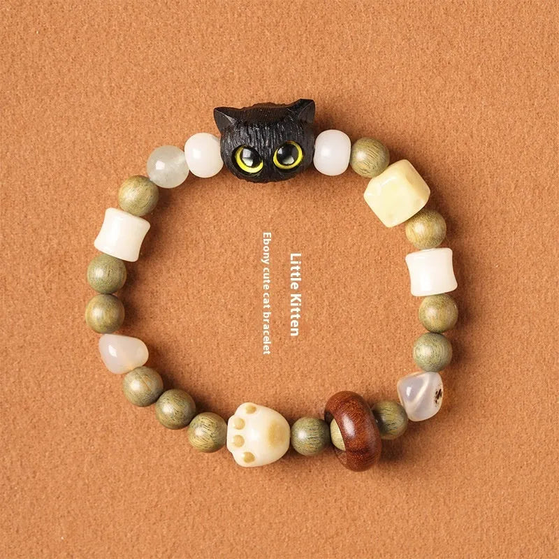 Hand-woven bracelet with bodhi seeds, jade, and wood featuring cartoon cat charm in multiple colour options