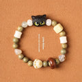Hand-woven bracelet with bodhi seeds, jade, and wood featuring cartoon cat charm in multiple colour options