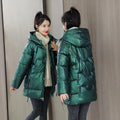 Green loose thick hooded women's winter jacket on a hanger, showing long sleeves and front zip.