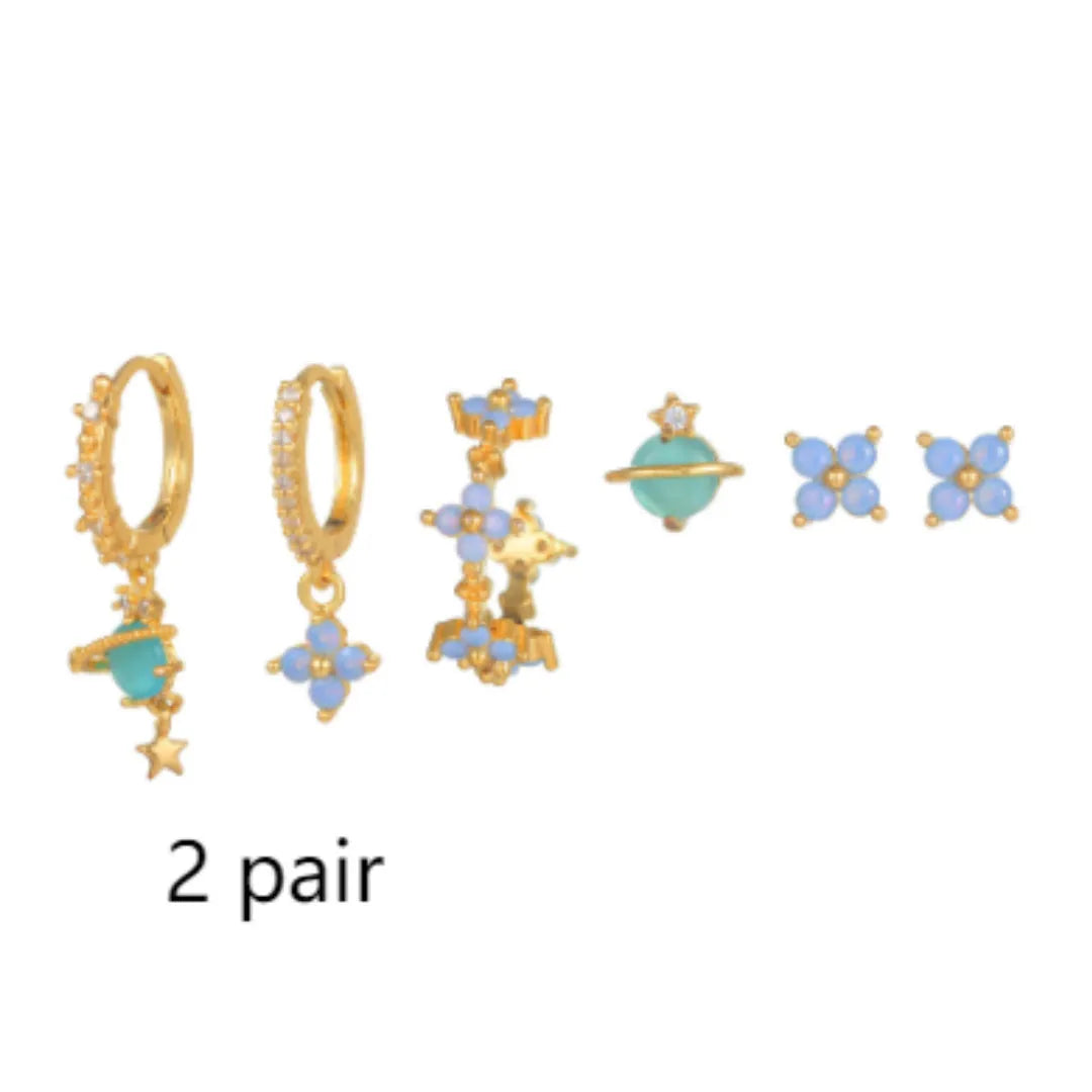 Gold and silver flower-shaped ear studs with blue zircon mosaic decoration.